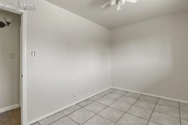 an empty room with chandelier fan