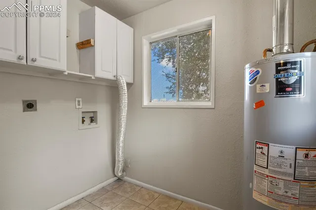 a view of an empty room with window and chandelier fan