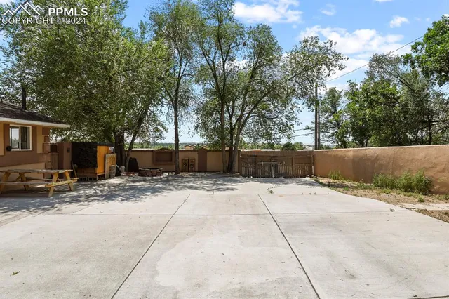 a view of house with yard and sitting area