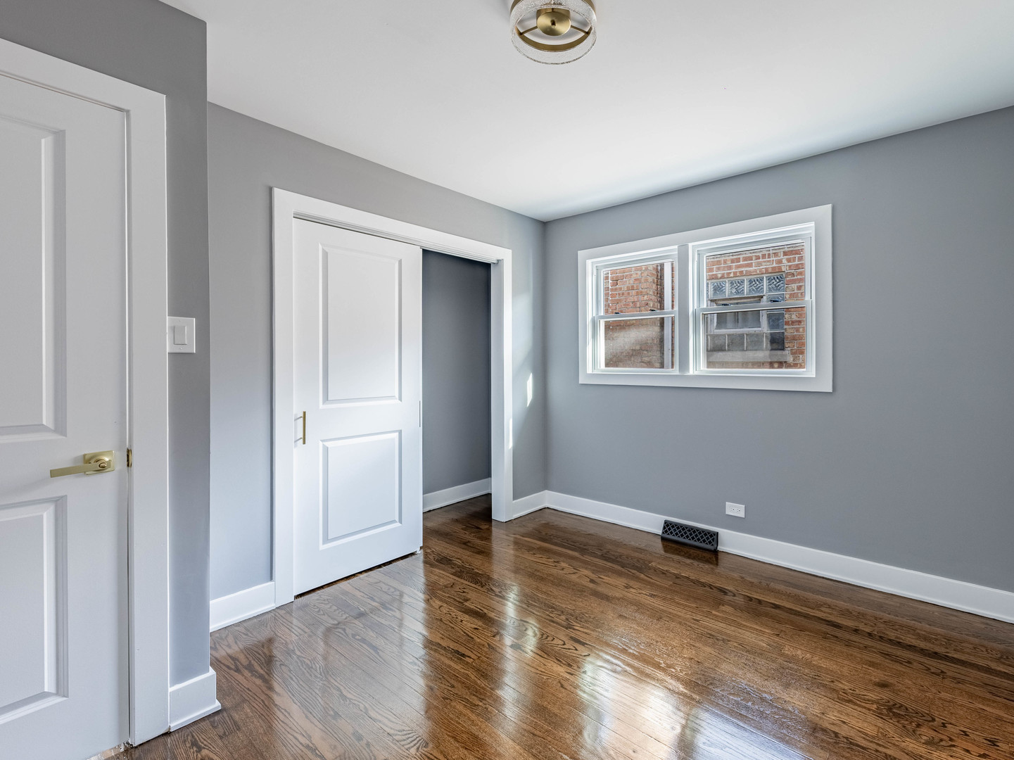 3053 West 77th Street Chicago, IL 60652 - Photo 5 of 23 an empty room with wooden floor and windows