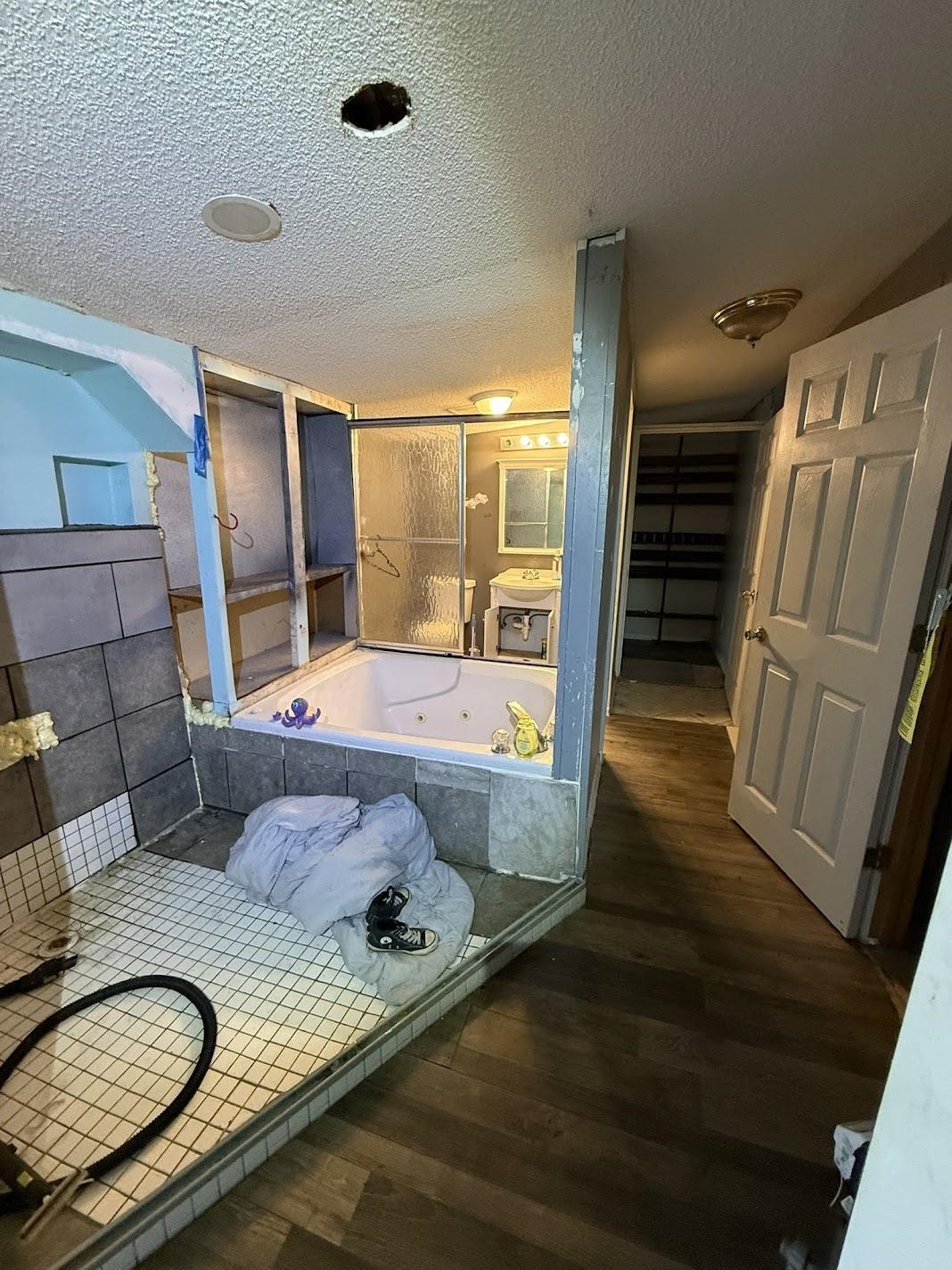 3794 Lucy Road Millington, TN 38053 - Photo 17 of 40 Bathroom featuring a built-in jetted tub, a tiled shower pan, a vanity with a mirror, and wood-finish flooring