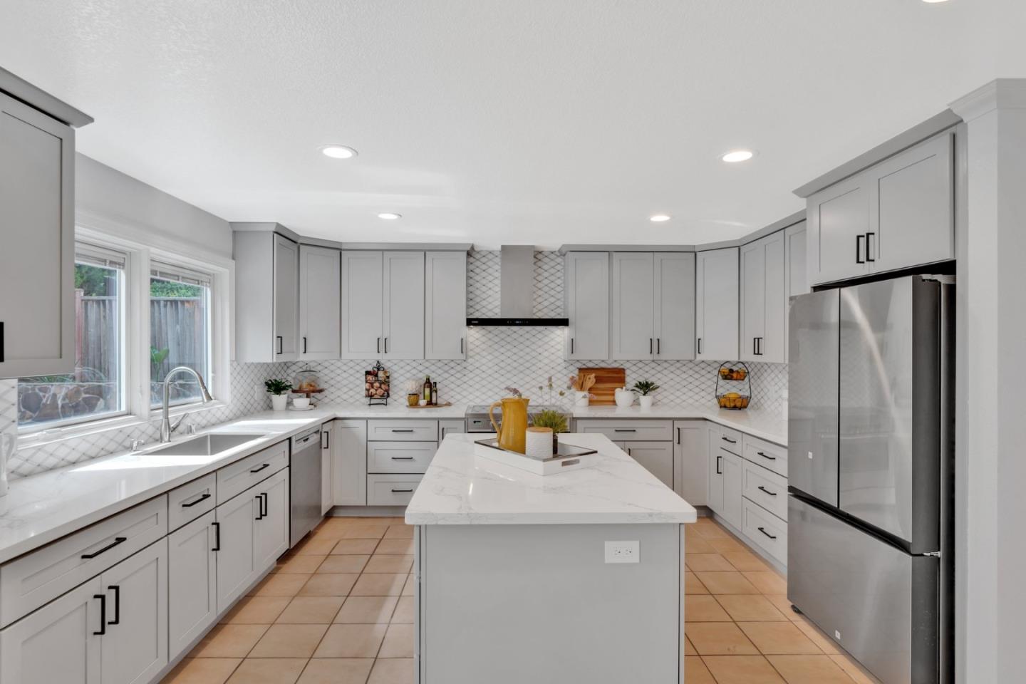 46950 Zapotec Drive Fremont, CA 94539 - Photo 11 of 40 a kitchen with a sink a refrigerator and white cabinets