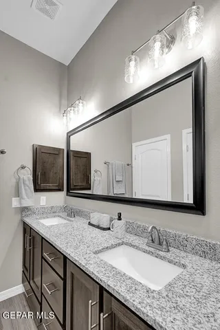 a bathroom with a granite countertop sink double and mirror