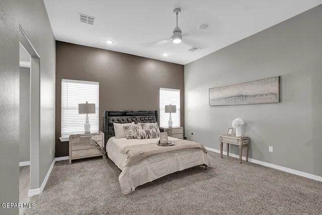 a bedroom with a large bed and a chandelier