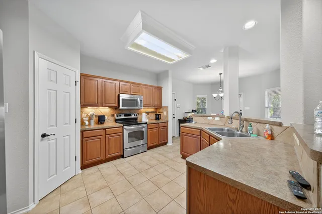 a kitchen with stainless steel appliances granite countertop a sink dishwasher stove refrigerator and cabinets