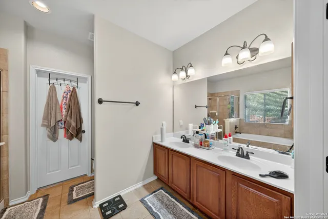 a bathroom with a double vanity sink a mirror and a bathtub