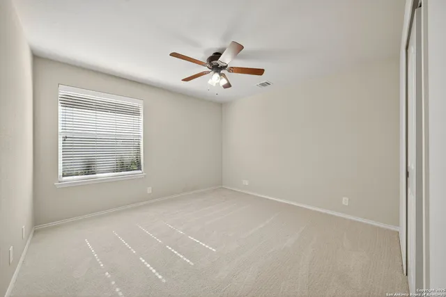 an empty room with a window and a fan