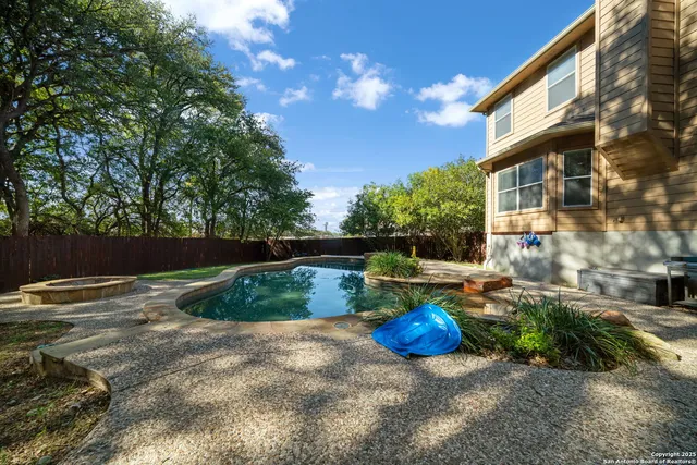 a view of a backyard with table and chairs potted plants and lake view