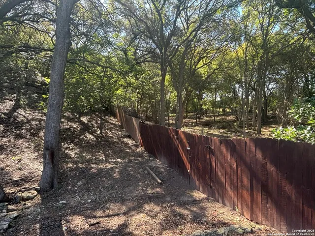a view of a yard with wooden fence