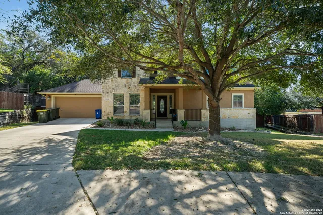 a view of a house with backyard and trees