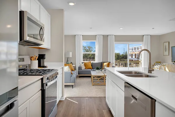 a kitchen with stainless steel appliances granite countertop a sink stove cabinets and wooden floor