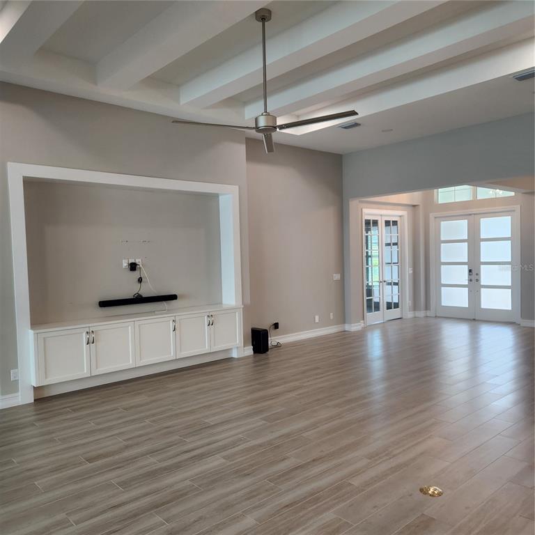 512 Blue Shell Loop Sarasota, FL 34240 - Photo 4 of 44 a view of an empty room with window and wooden floor
