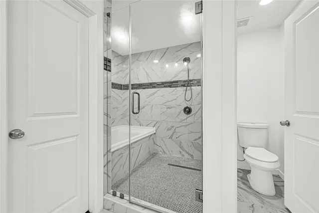 a bathroom with a shower a toilet and sink