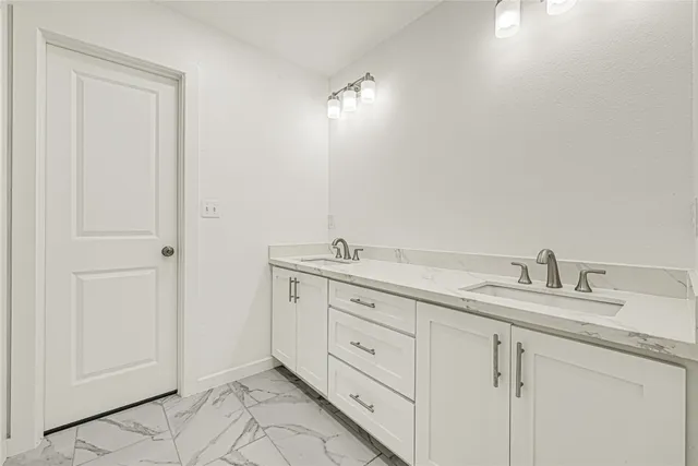 a spacious bathroom with double sink and a mirror
