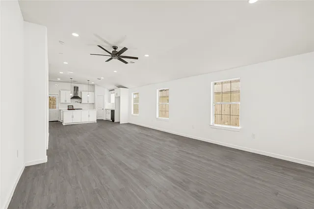 wooden floor in an empty room with a kitchen