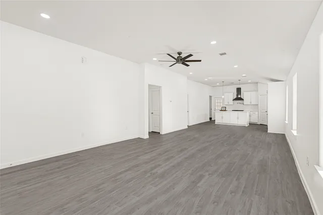 a view of empty room with wooden floor and window