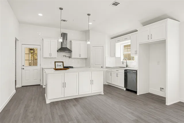 a kitchen with white cabinets stainless steel appliances and a sink
