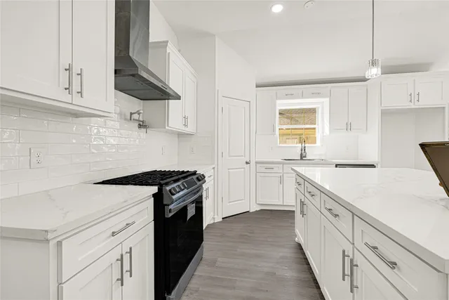 a kitchen with a stove sink and cabinets
