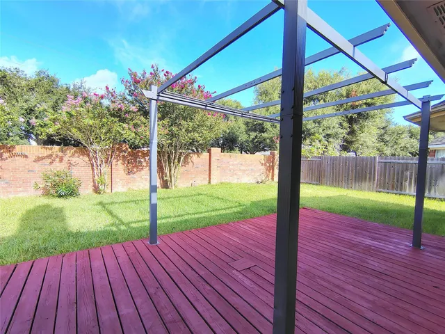 a view of a yard with porch and wooden fence