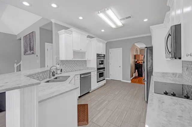 a kitchen with stainless steel appliances granite countertop a sink and cabinets
