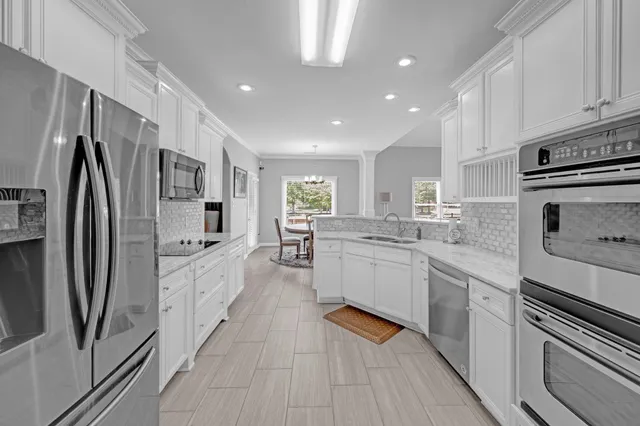 a large kitchen with stainless steel appliances granite countertop a sink and cabinets