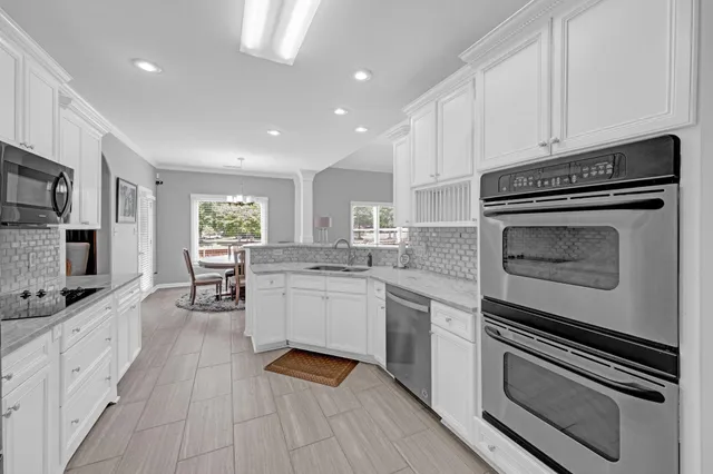 a kitchen with white cabinets and stainless steel appliances