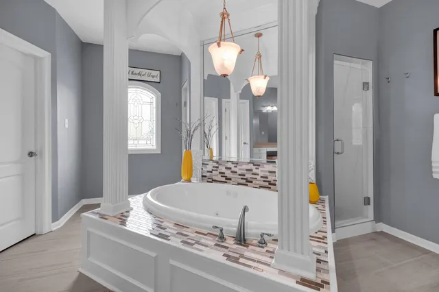 a spacious bedroom with a bed a dresser and mirrors