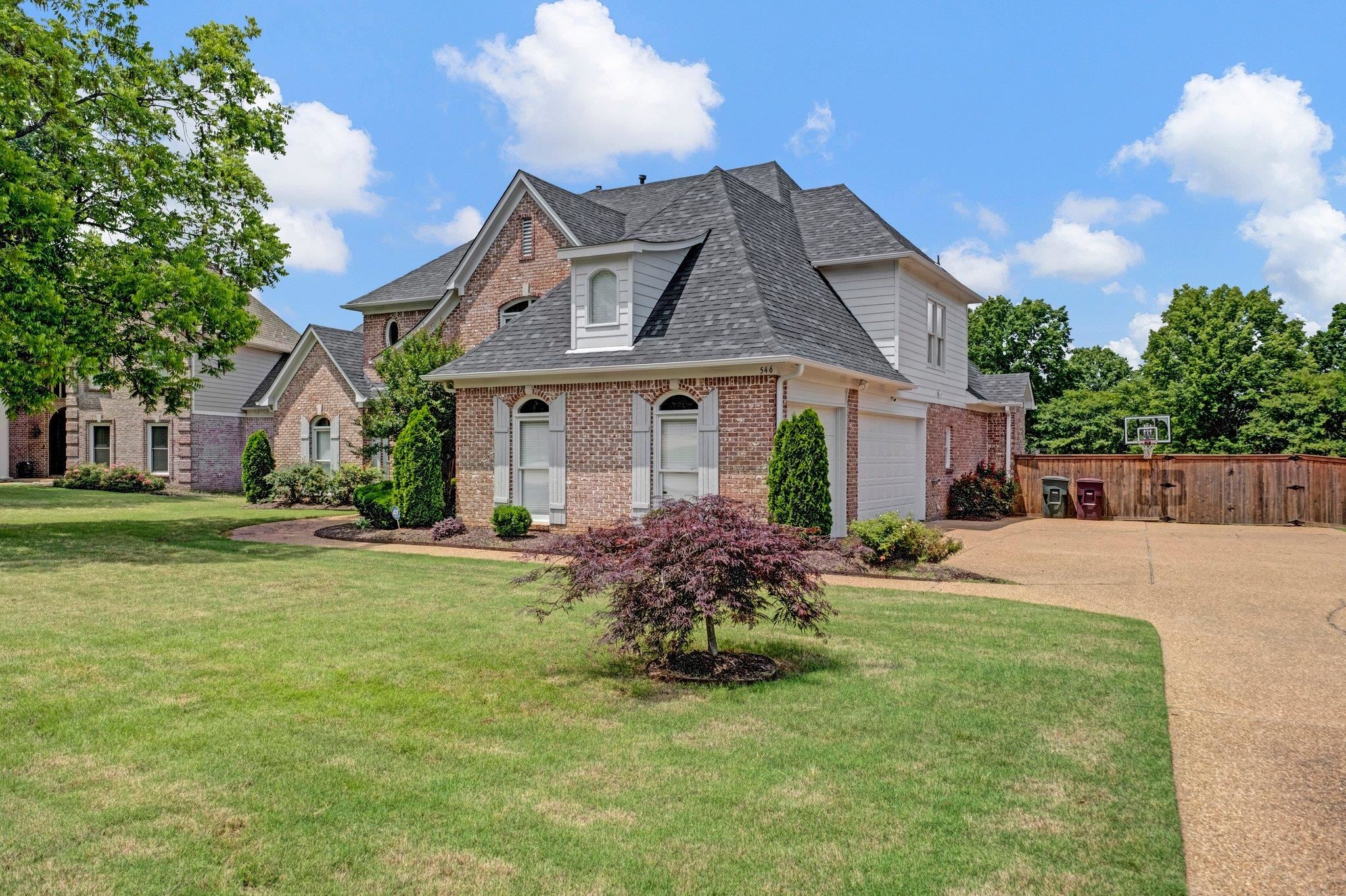 546 Township Cove Collierville, TN 38017 - Photo 22 of 40 Beautifully landscaped with concrete driveway, brick siding, roof with shingles, and an attached 3-car garage and a beautiful Japanese Maple Tree.