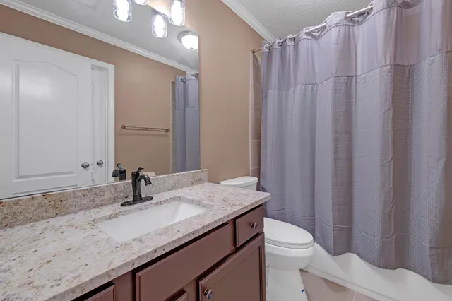 a bedroom with a bed a flat screen tv and a large window