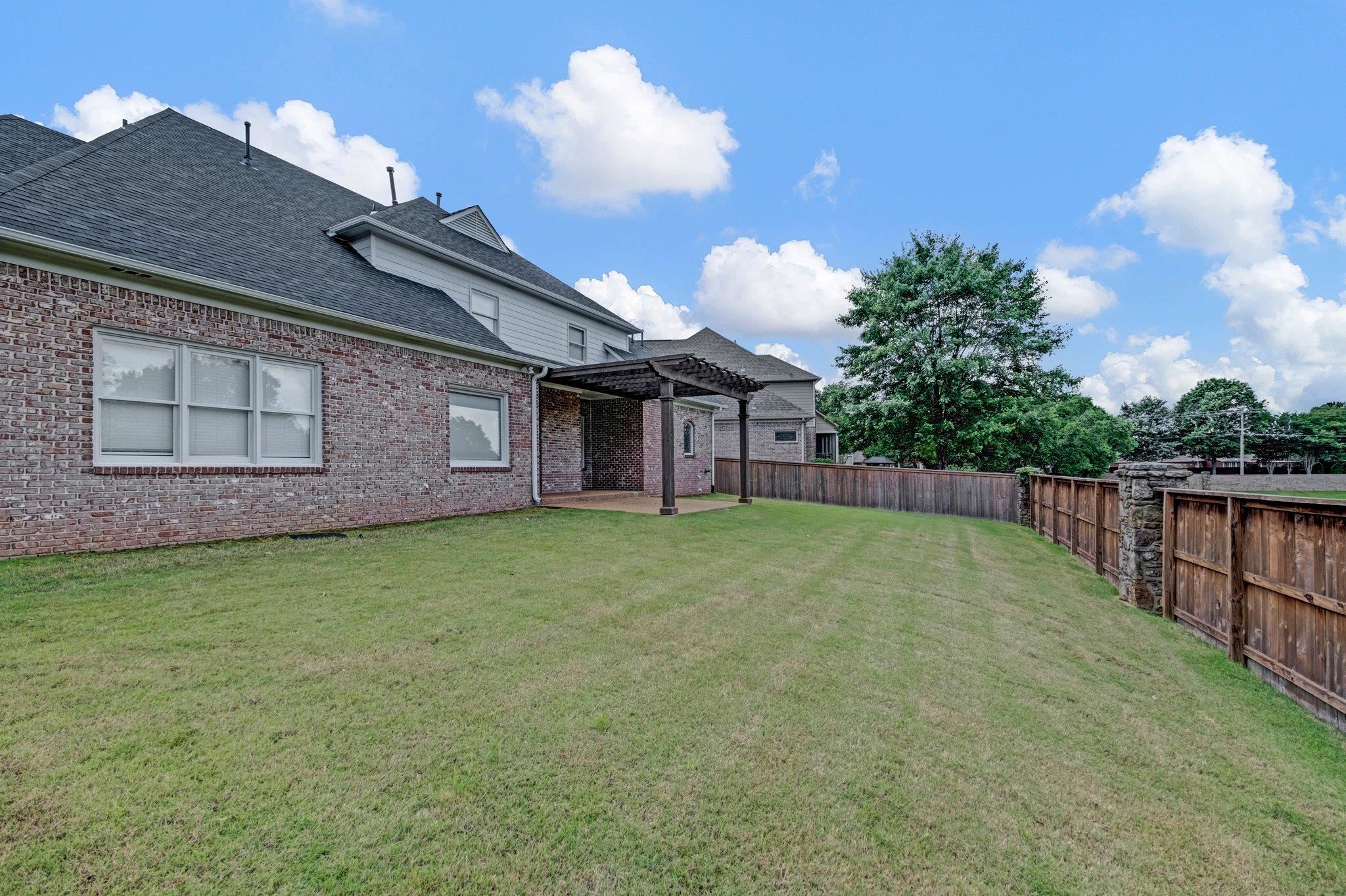 546 Township Cove Collierville, TN 38017 - Photo 38 of 40 View of yard featuring a pergola and a patio area. Neighborhood Pond View over the fence.