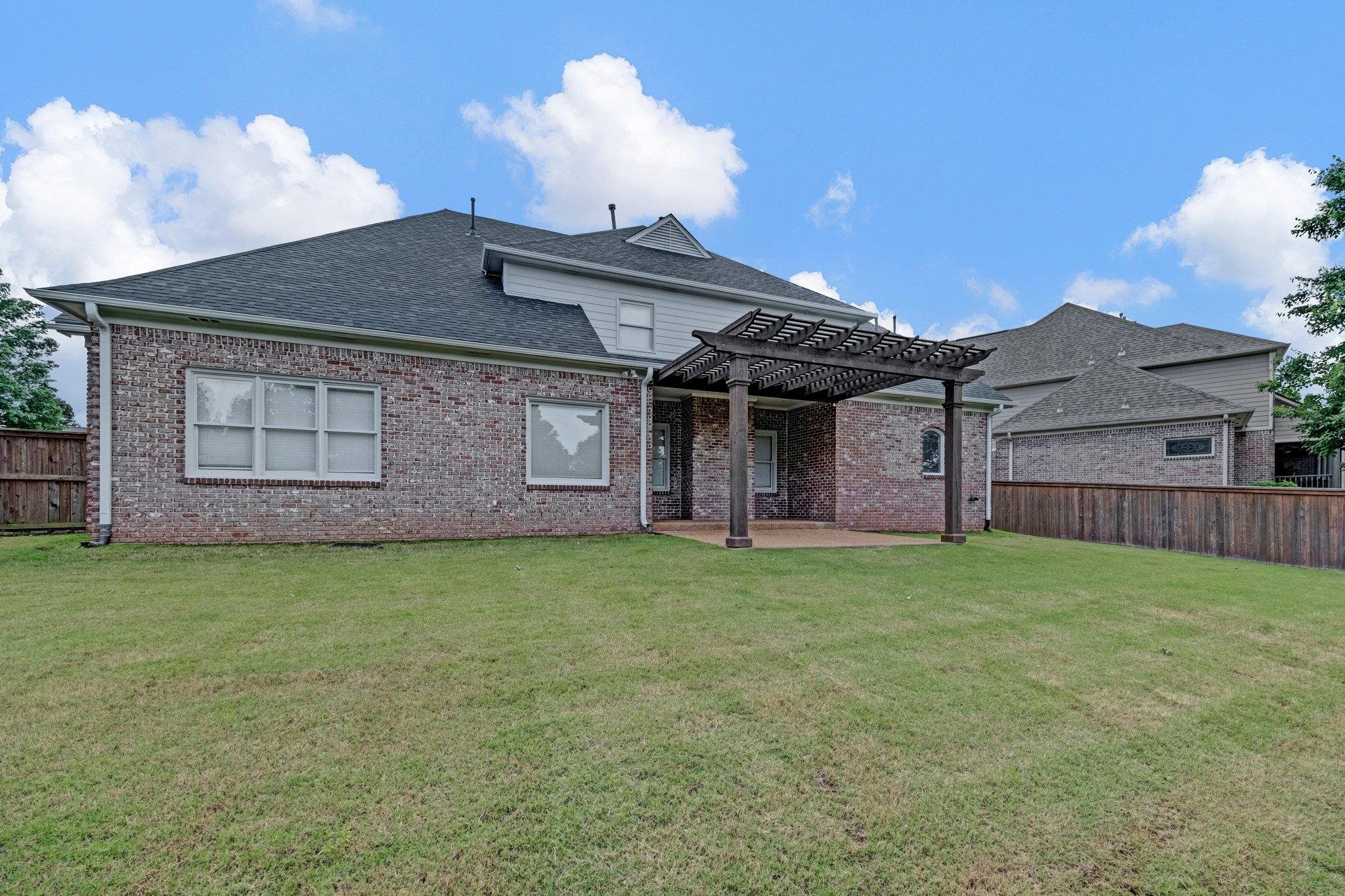 546 Township Cove Collierville, TN 38017 - Photo 39 of 40 Rear view of house featuring a pergola, a patio, roof with shingles, and brick siding.