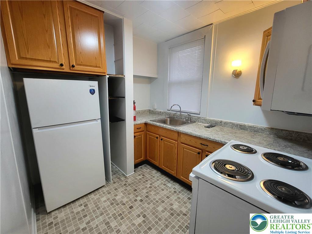 817 Seneca Street, Unit B Fountain Hill, PA 18015 - Photo 8 of 12 a kitchen with a refrigerator and a stove
