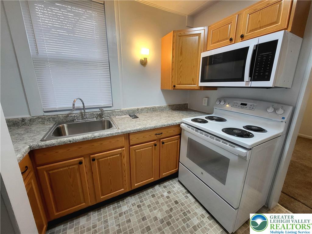817 Seneca Street, Unit B Fountain Hill, PA 18015 - Photo 9 of 12 a kitchen with stainless steel appliances granite countertop a sink and a microwave