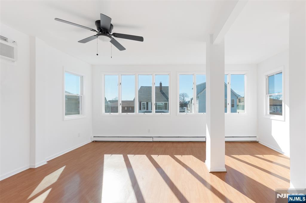 118 Ray Street, Unit 2 Garfield, NJ 07026 - Photo 2 of 15 a view of an empty room with wooden floor and a window