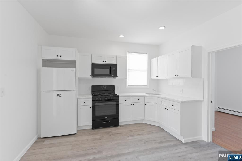 118 Ray Street, Unit 2 Garfield, NJ 07026 - Photo 7 of 15 a kitchen with granite countertop a refrigerator stove and sink