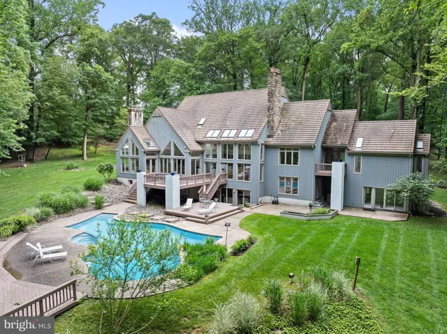 a view of a house with a big yard potted plants and a large tree