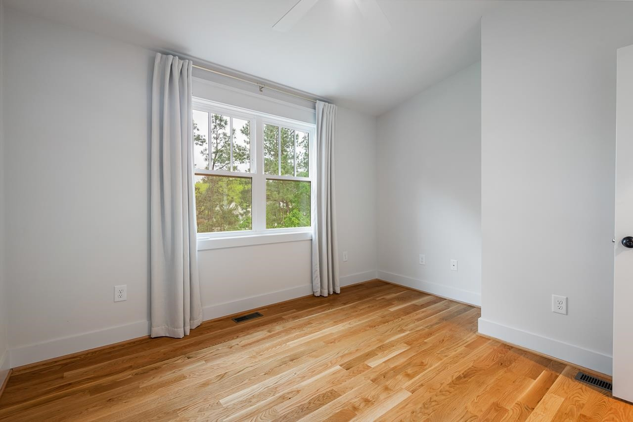 601 Jerome Road Durham, NC 27713 - Photo 42 of 52 an empty room with wooden floor and windows