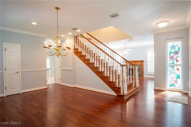 a view of a hallway with wooden floor and staircase
