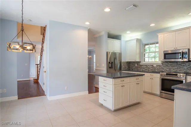 a kitchen with stainless steel appliances granite countertop a refrigerator and a stove top oven