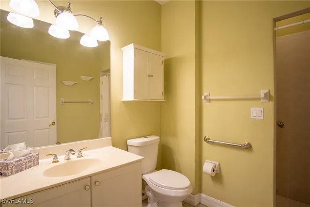 a view of a hallway with wooden floor and a bathroom