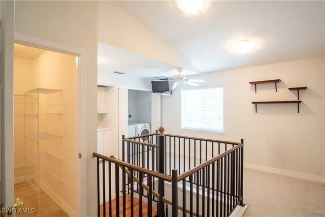 a view of an empty room with a floor to ceiling windows and front door