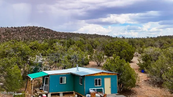 an aerial view of a house with a mountain in the background