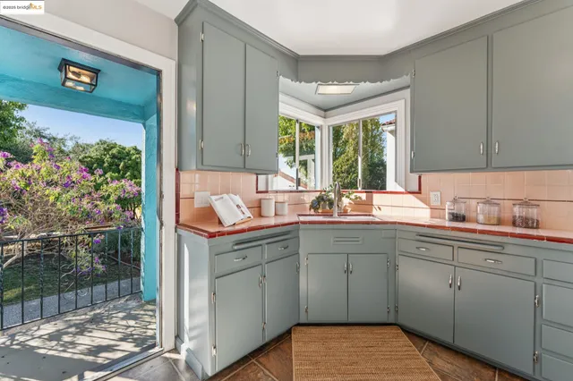 a living room with furniture potted plant and kitchen view