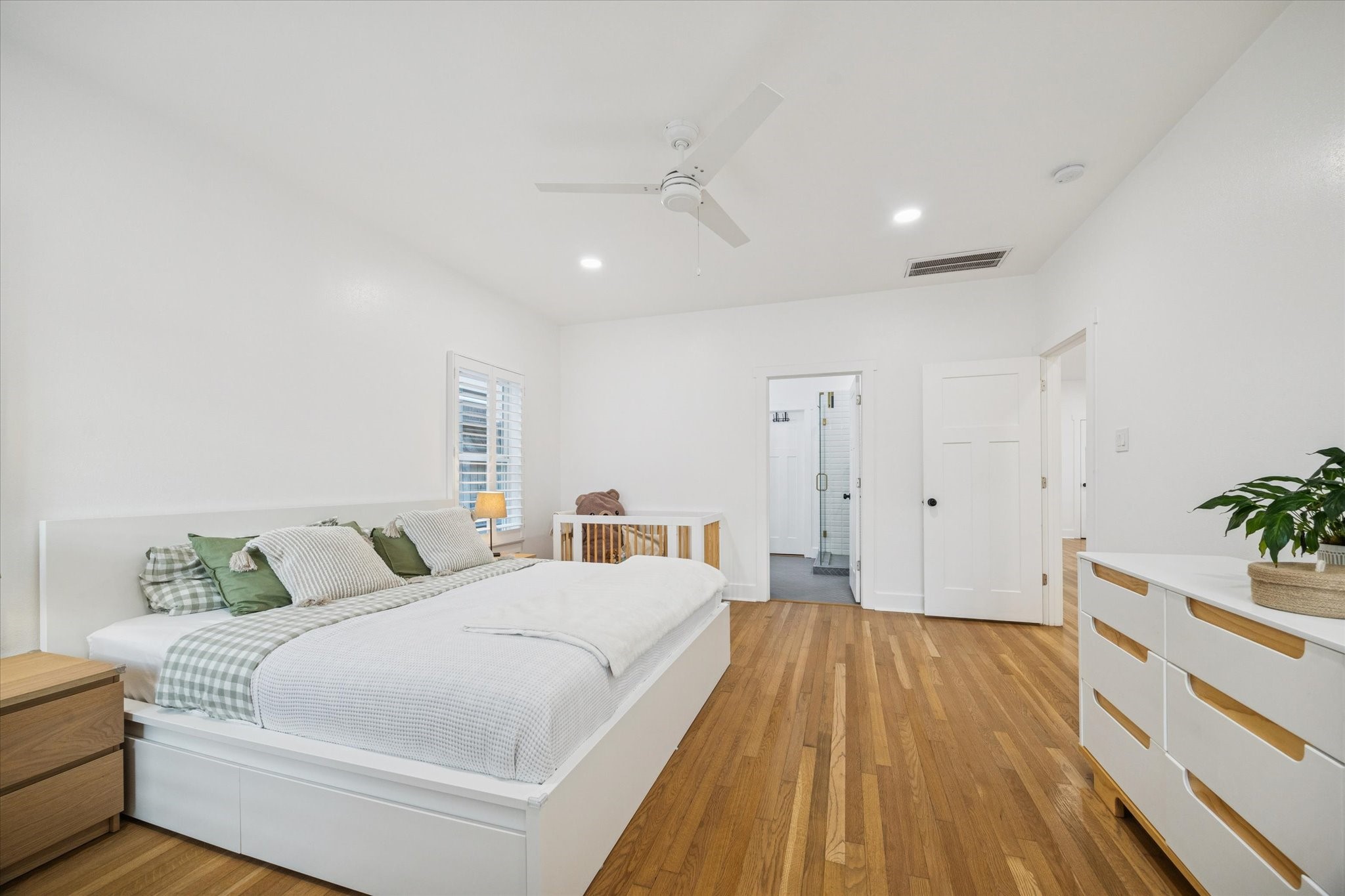 207 Tabor Street Houston, TX 77009 - Photo 11 of 25 a spacious bedroom with a bed and a potted plant