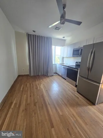 a view of kitchen with wooden floor electronic appliances and window