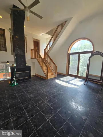 an empty room with stairs and wooden floor