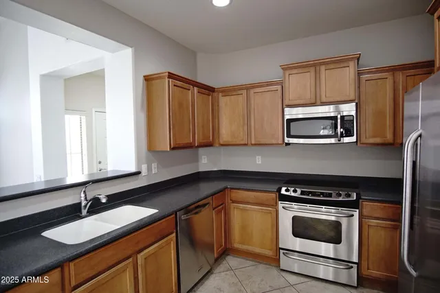 a kitchen with granite countertop a sink stove and microwave
