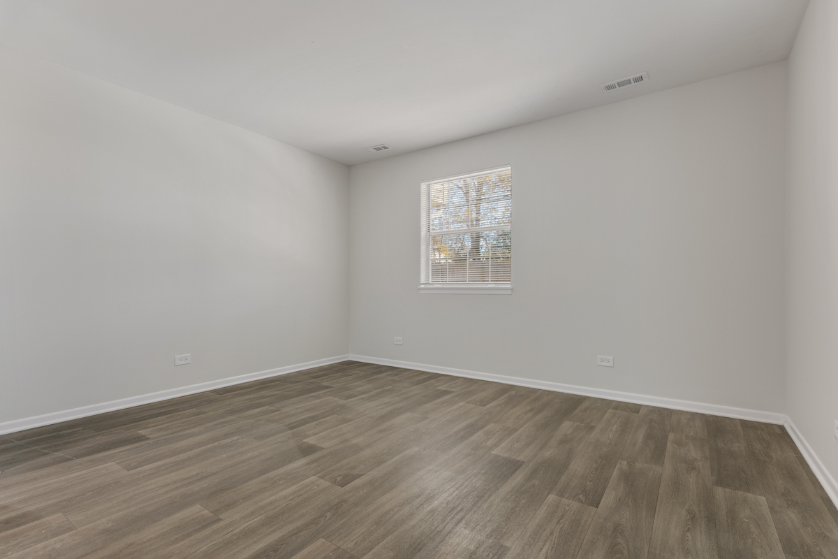 96 Gant Circle, Unit B Streamwood, IL 60107 - Photo 11 of 21 an empty room with wooden floor and windows