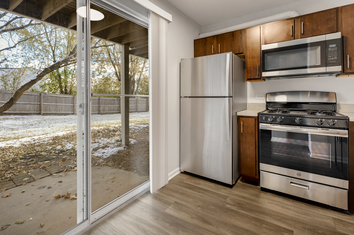 96 Gant Circle, Unit B Streamwood, IL 60107 - Photo 5 of 21 a kitchen with granite countertop a refrigerator and a stove