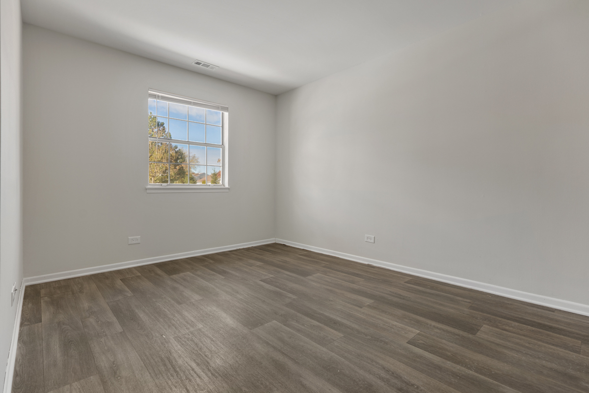96 Gant Circle, Unit B Streamwood, IL 60107 - Photo 8 of 21 an empty room with wooden floor and window
